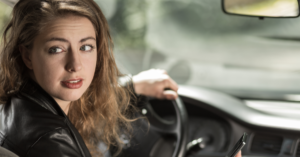 young woman distracted while driving car