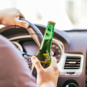 man drinking alcohol while driving the car