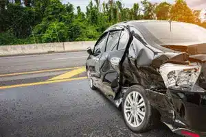 Black car damaged after an accident on the highway