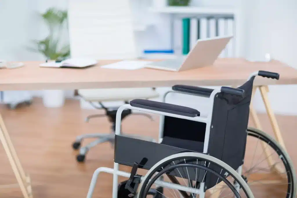 A wheelchair by a desk and laptop
