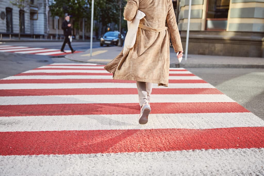 back of woman crossing the road