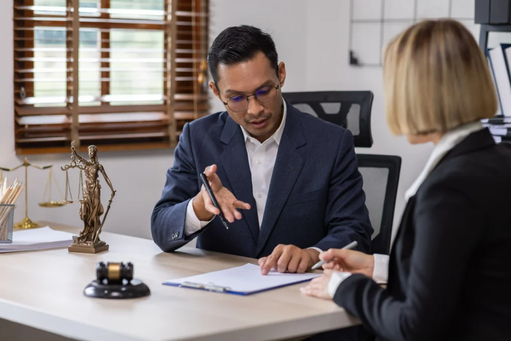 Man and woman talking over paperwork with a gavel on the table