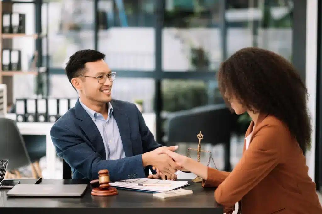 Two people talking over paperwork with a gavel on the table