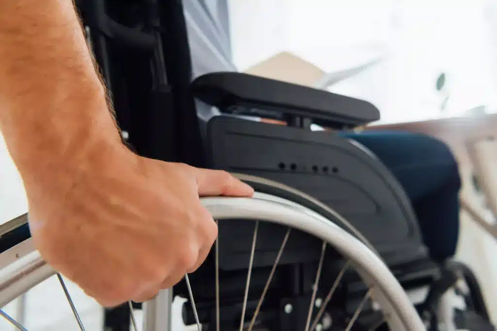 Close up of man holding wheel of wheelchair