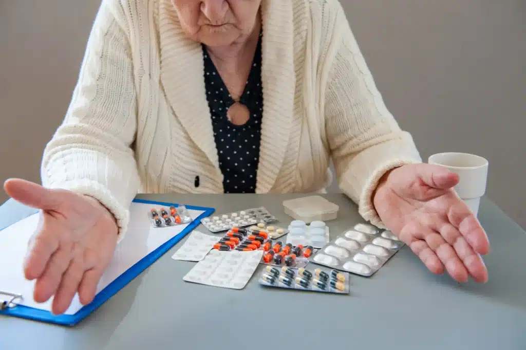 Elderly Woman With Beautiful Wrinkled Face Is Holding Pills In Her Hands To Choose Medicines
