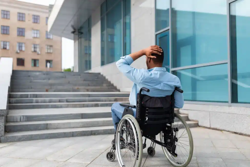 Irritated impaired black man in wheelchair having no possibility to enter building without ramp