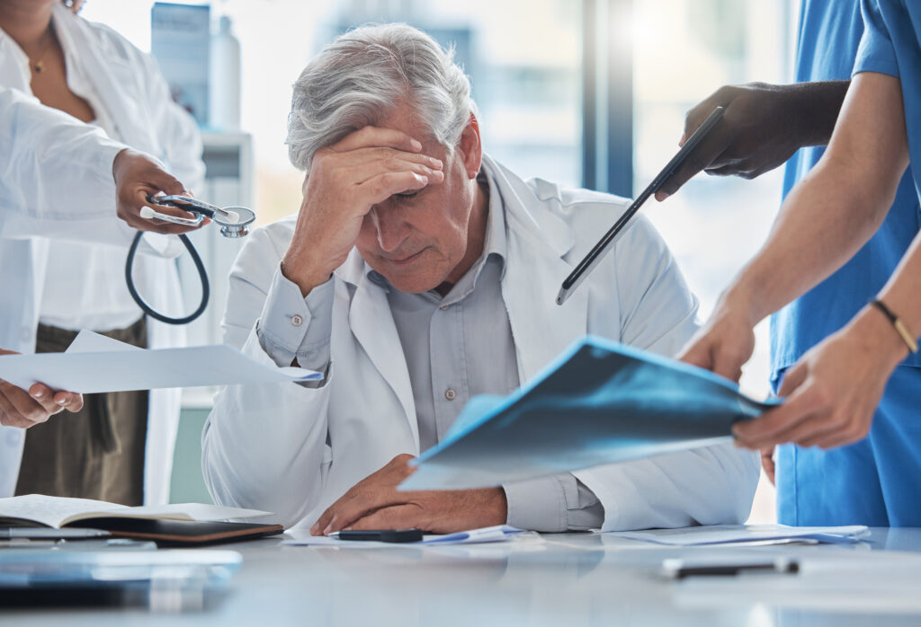 doctor being overwhelmed with other hospital workers around