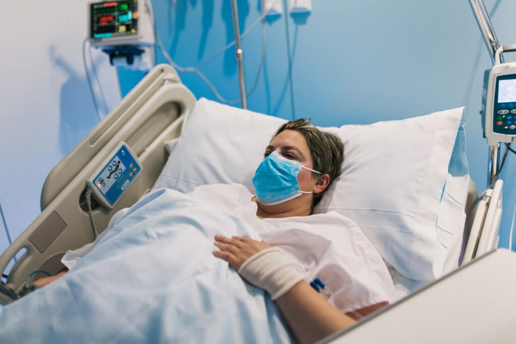 woman wearing mask in hospital ward